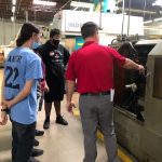 Avanti Engineering professionals demonstrating machining techniques to local students.